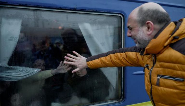 أوكراني يودع عائلته باكيا في محطة القطار بأوديسا (أ. ف. ب)