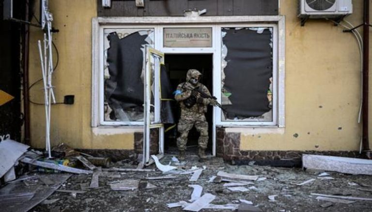 جندي أوكراني يخرج من مبنى مدمر - الفرنسية