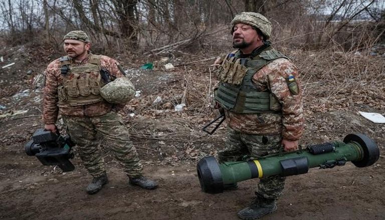 أفراد الخدمة الأوكرانية يحملون نظاما صاروخيا