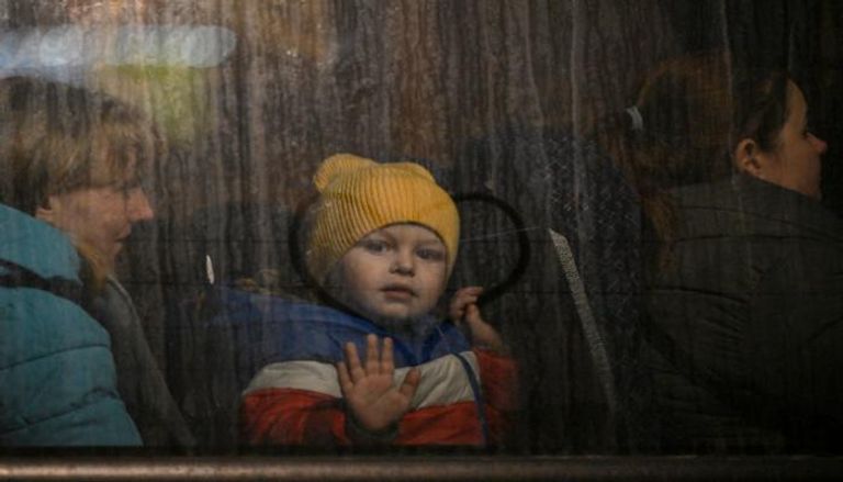 طفل أوكراني يلوح بيده عقب عبور الحدود نحو بولندا (أ. ف. ب)