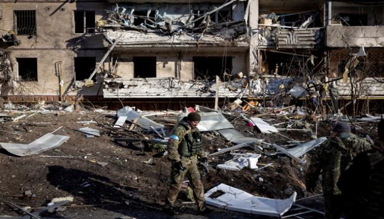 جندي أوكراني يتفقد مبنى مدمرا في كييف (أ. ف. ب)