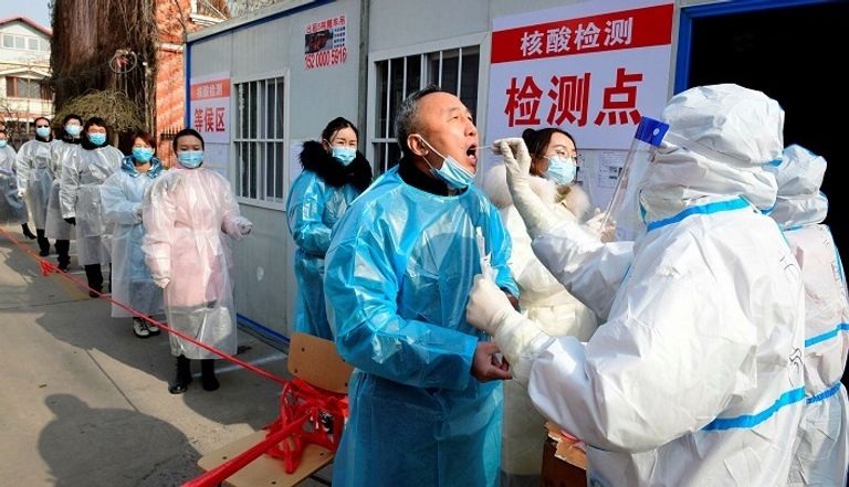 أشخاص يخضعون لفحص كورونا بالصين- أرشيفية