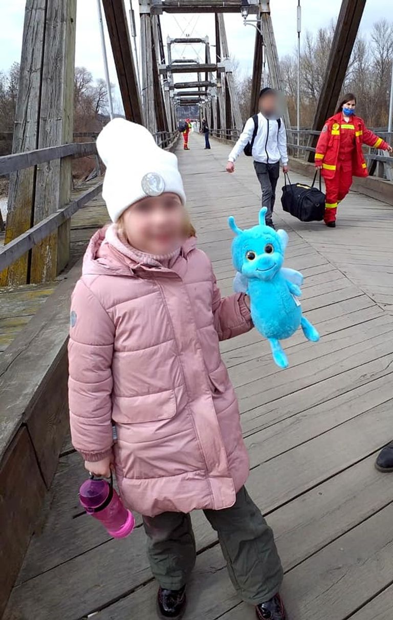 شرطية من حرس الحدود الروماني تحمل الألعاب للأطفال اللاجئين