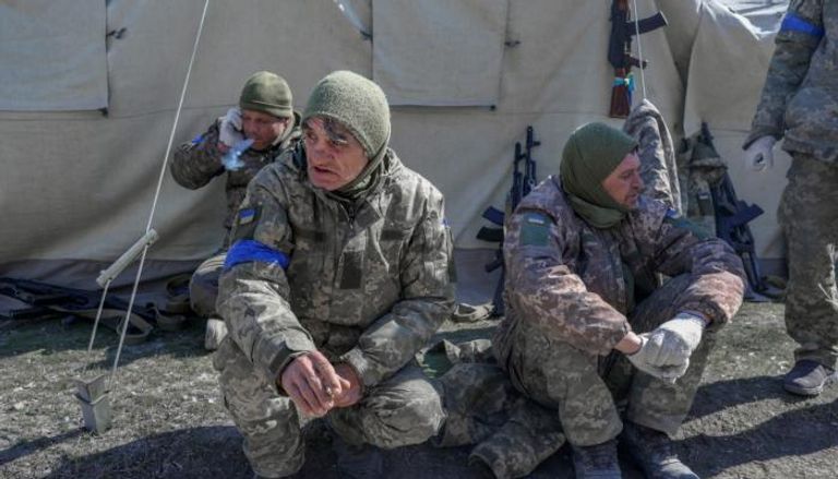 جنود أوكرانيون يجلسون بجانب مدرسة عسكرية