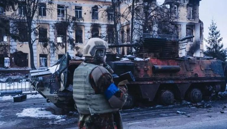 جندي أوكراني يمر بجانب آليه روسية محترقة