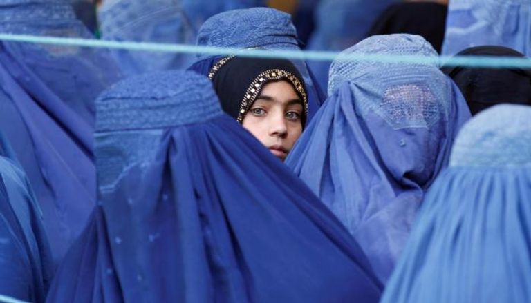 فتاة أفغانية تطل بين رفيقاتها بالبرقع 