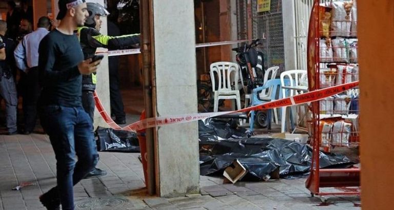 شرطيان إسرائيليان بالقرب من دراجة هوائية استخدمها مطلق النار