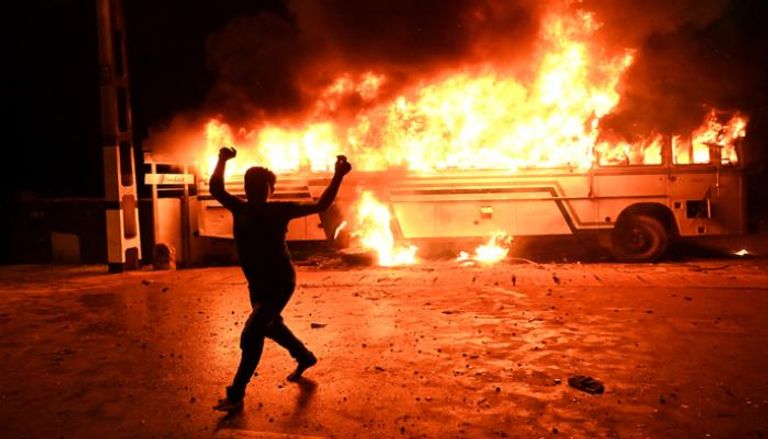 متظاهر سريلانكي يهتف بشعارات بعد إشعال النار في حافلة (أ. ف. ب)