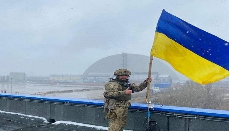 جندي أوكراني يرفع العلم على مجمع تشيرنوبيل - رويترز