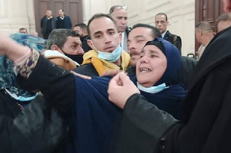 أسرة المجني عليها تحمل صورتها