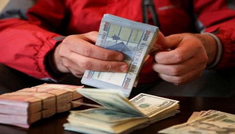 أوراق نقدية من الدولار والليرة - أرشيفية