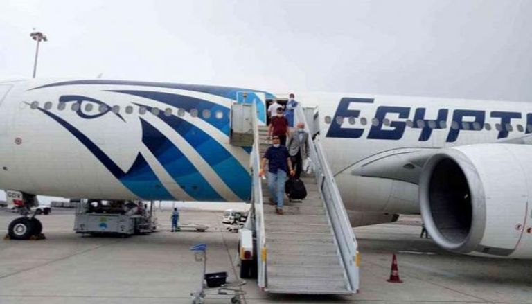 مسافرون يغادرون إحدى ناقلات مصر للطيران بمطار القاهرة الدولي - أرشيفية