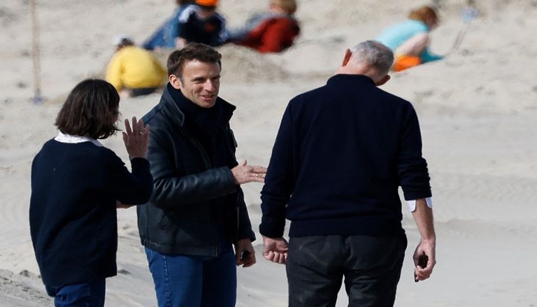 ماكرون وزوجته في جولة شاطئية الرئيس الفرنسي المتهية ولايته خلال نزهة الشاطئ