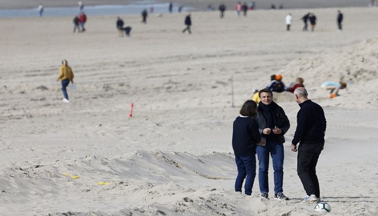 ماكرون وزوجته في جولة شاطئية الرئيس الفرنسي المتهية ولايته خلال نزهة الشاطئ