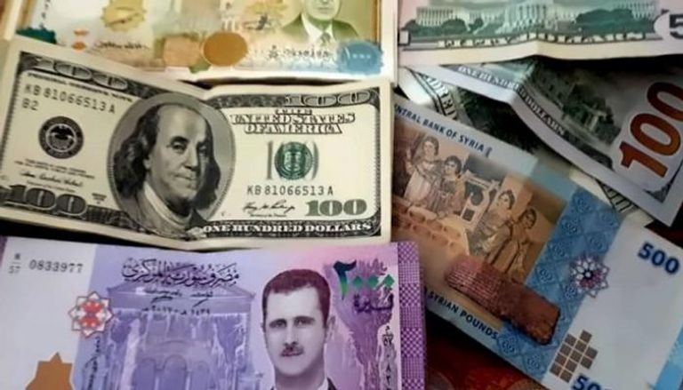 أوراق نقدية فئة 100 دولار وليرات سورية- أرشيفية