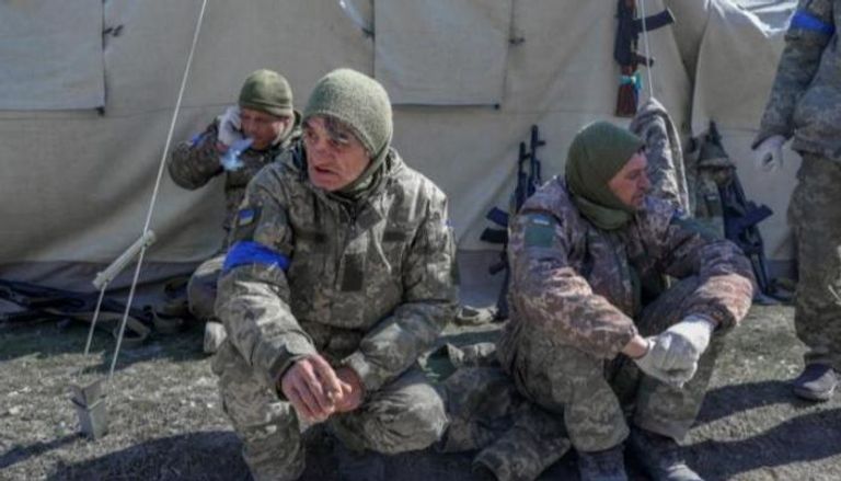 جنود أوكرانيون يجلسون بجانب مدرسة عسكرية- رويترز