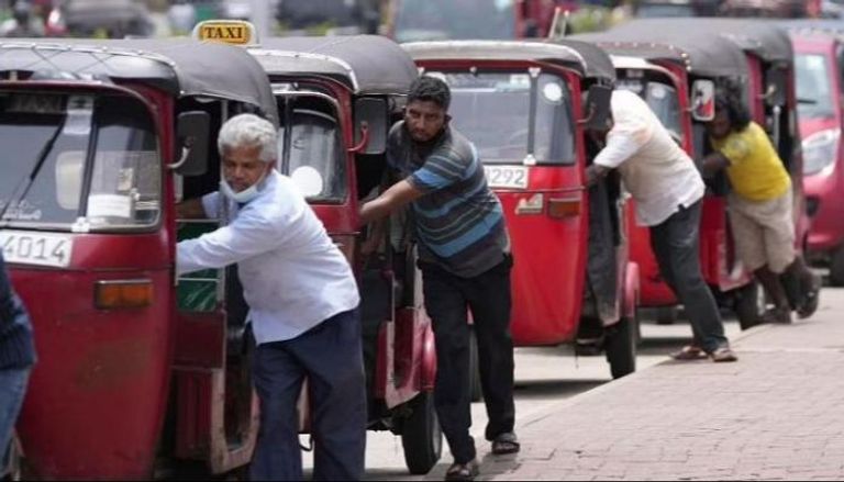 سائقو عربات الريكاشة السريلانكية يصطفون لشراء البنزين قرب محطة وقود في كولومبو
