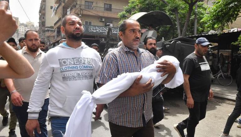 والد إحدى ضحايا الزورق يحمل ابنته