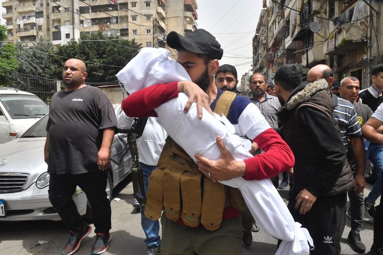 والد إحدى ضحايا الزورق يحمل ابنته