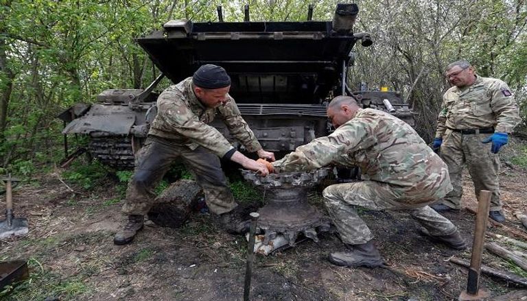 جنود أوكرانيون يصلحون دبابة في موقع