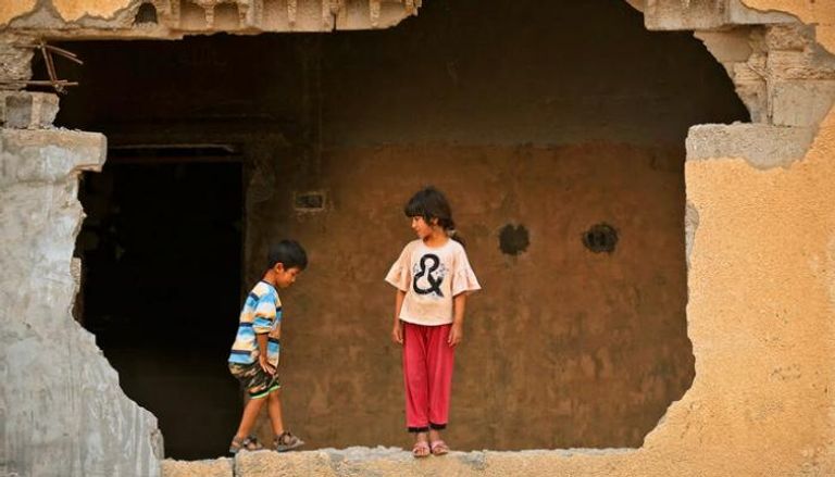 طفلان يلعبان في مبنى مدمر ببلدة حبش شمالي العراق (أ. ف. ب)
