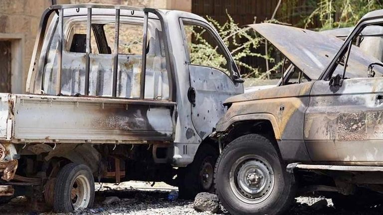 أطفال يمنيون يقفون أمام سيارة مدمرة جراء التفجير