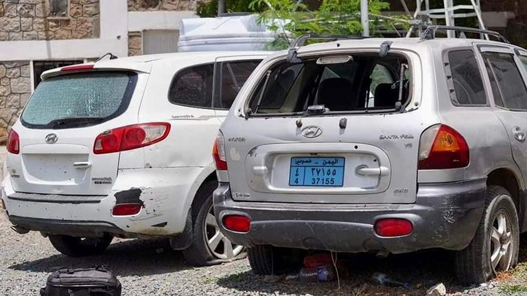 أطفال يمنيون يقفون أمام سيارة مدمرة جراء التفجير