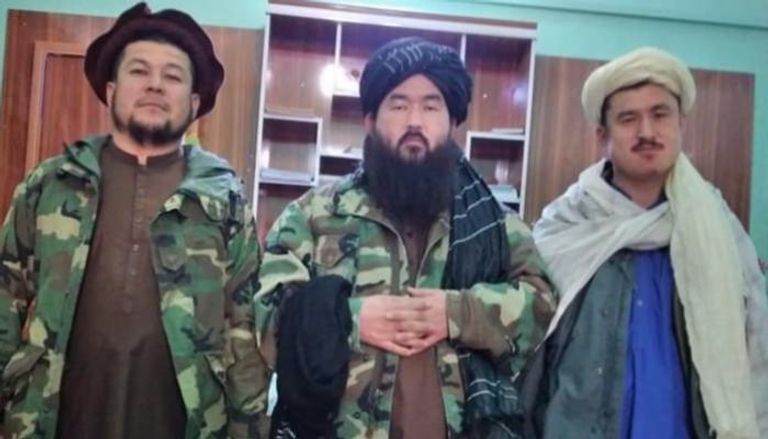 قاري نور الدين المسؤول بحركة طالبان يتوسط اثنين من عناصر الحركة