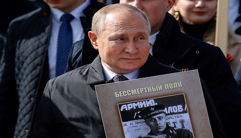 الرئيس الروسي فلاديمير بوتين يحمل صورة والده باحتفالات 