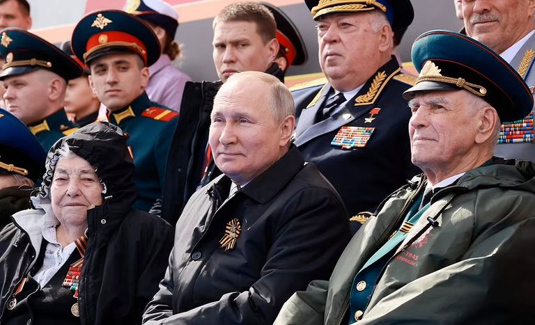 بوتين يمين الصورة واضعا غطاء على قدميه