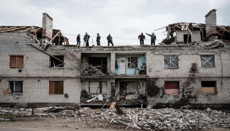 عمال يزيلون آثار الدمار جراء الحرب في أوكرانيا