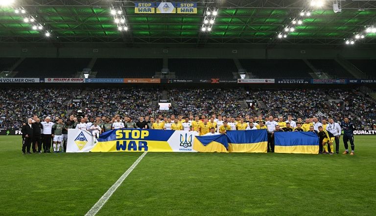 لاعبو الفريقين يرفعون لافتة مكتوب عليها "أوقفوا الحرب" الجماهير تشجع منتخب أوكرانيا