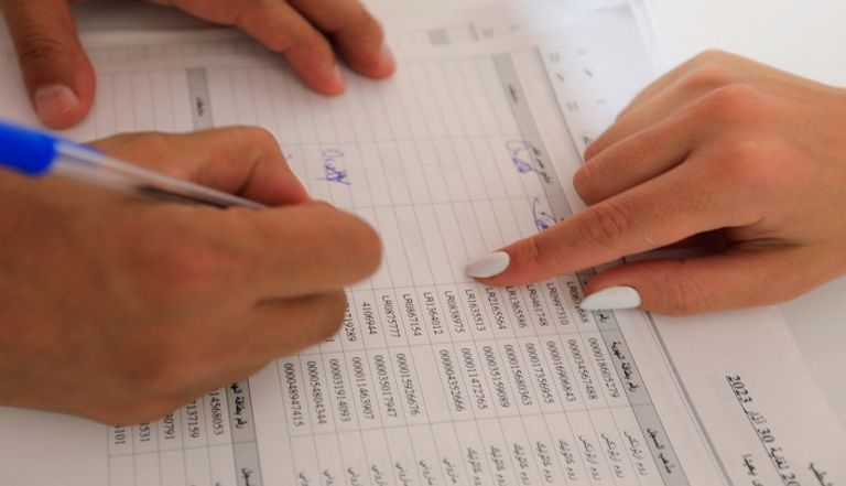 ناخبة تبحث عن اسمها في كشوف الناخبين صندوق اقتراع في الانتخابات اللبنانية