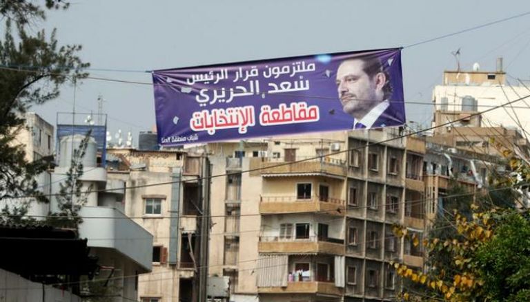  لافتة تؤكد الالتزام بقرار سعد الحريري في أحد شوارع بيروت (أ ف ب)