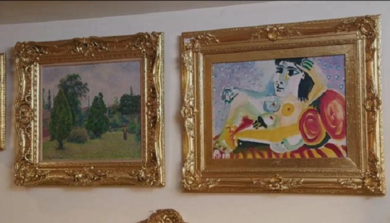 إيميلدا ماركوس وخلفها إلى اليمين لوحه بيكاسو