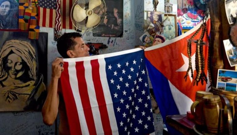 مواطن كوبي يرفع علمي بلاده والولايات المتحدة