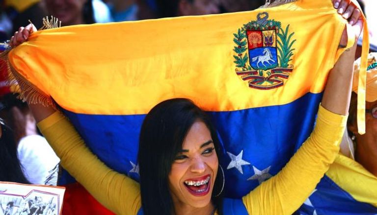 امرأة فنزويلية ترفع علام بلادها