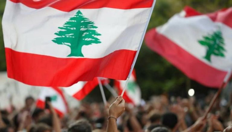 لبنانيون يلوحون بأعلام بلدهم - أرشيفية