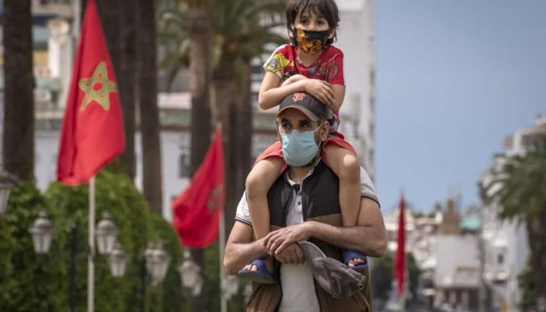 أب مغربي وطفله يرتديان كمامات - أرشيفية
