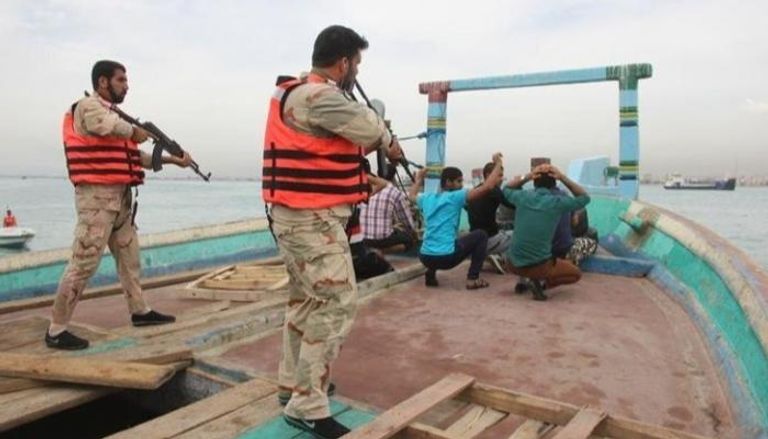 عنصران من الحرس الثوري الإيراني خلال عملية توقيف طاقم سفينة بزعم التهريب