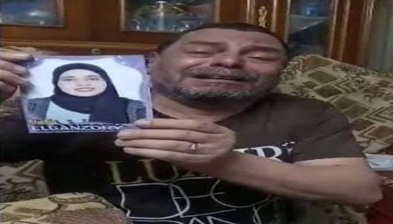 والد فتاة الشيخ زايد يحمل صورتها