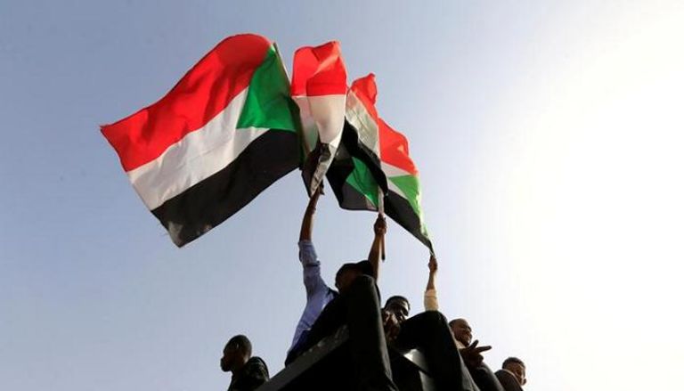 سودانيون يحملون أعلام بلادهم