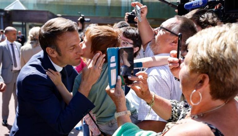طفل يقبل الرئيس الفرنسي إيمانويل ماكرون - وكالات