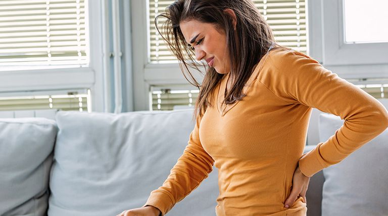 طفلة تضع كمامة وتنظر من خلف نافذة