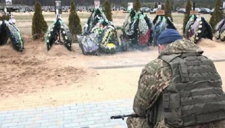 جندي أوكراني بجوار قبور رفاقه القتلى
