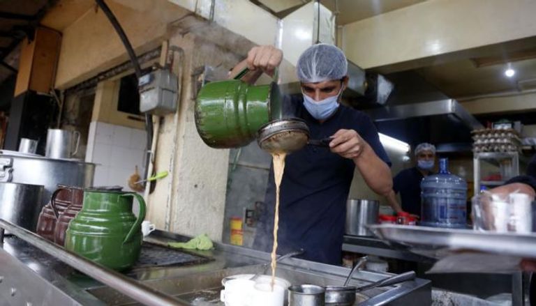 رجل يصنع الشاي بالحليب في متجر في إسلام أباد 