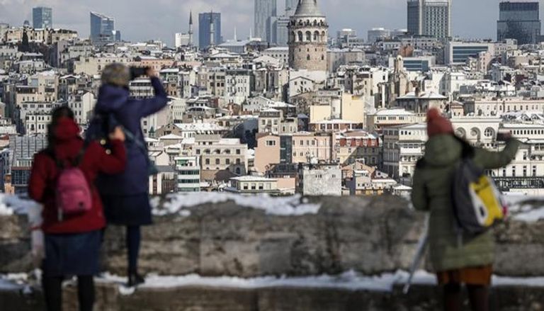 سياح أجانب يلتقطون صورًا تذكارية بإسطنبول