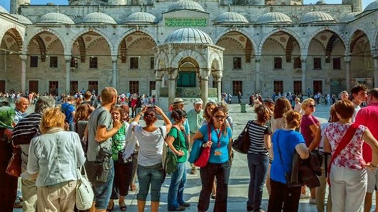 سياح أجانب يلتقطون صورًا تذكارية بإسطنبول