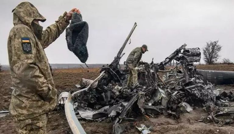 جندي أوكراني يتفحص بقايا مروحية مي 8 الروسية