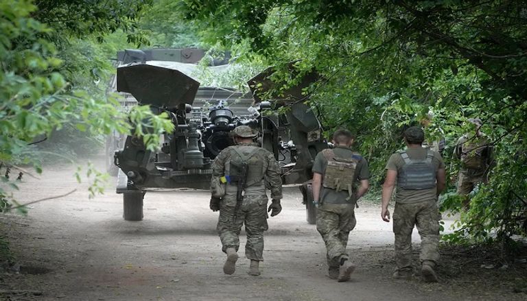 جنود أوكرانيون ينقلون معدات  عسكرية  عملية نقل مدفع هاوتزر إلى أحد المواقع في أوكرانيا